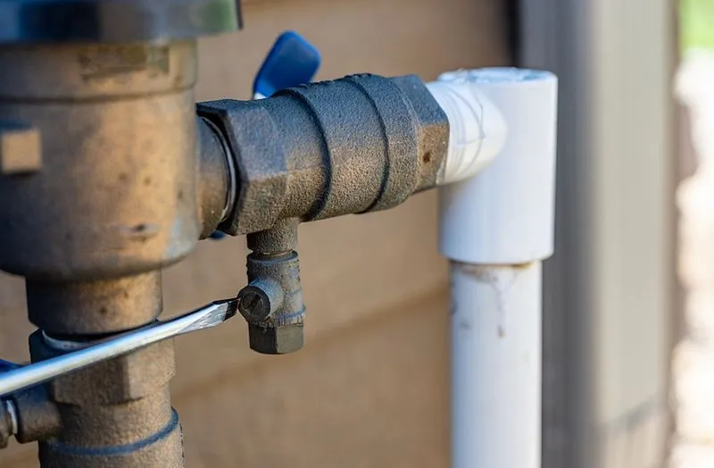 TCEQ-licensed tester performing annual backflow assembly test on an RPZ device